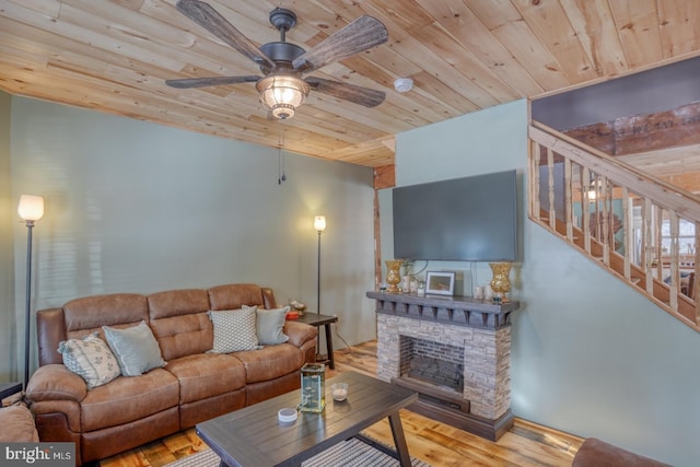 living room with ceiling fan, light wood-type flooring, wood ceiling, and a fireplace