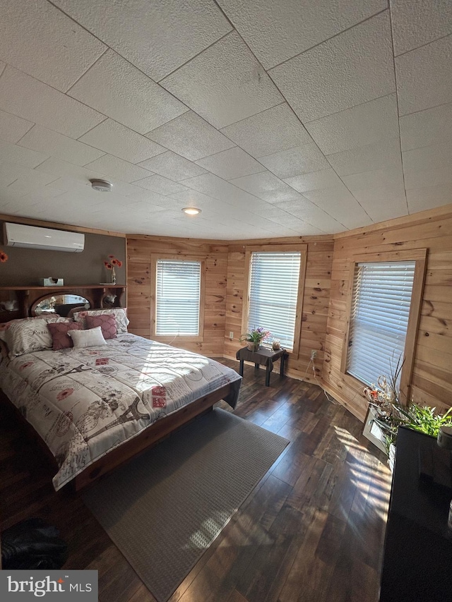 unfurnished bedroom with an AC wall unit, dark wood-type flooring, and wood walls