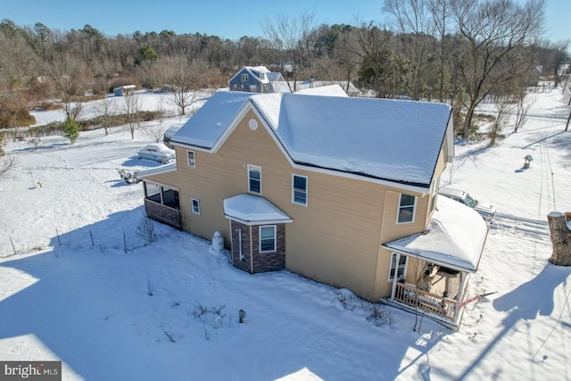 view of snow covered back of property