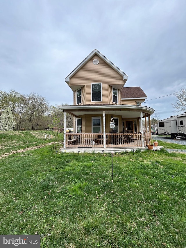 farmhouse inspired home with a front yard and covered porch