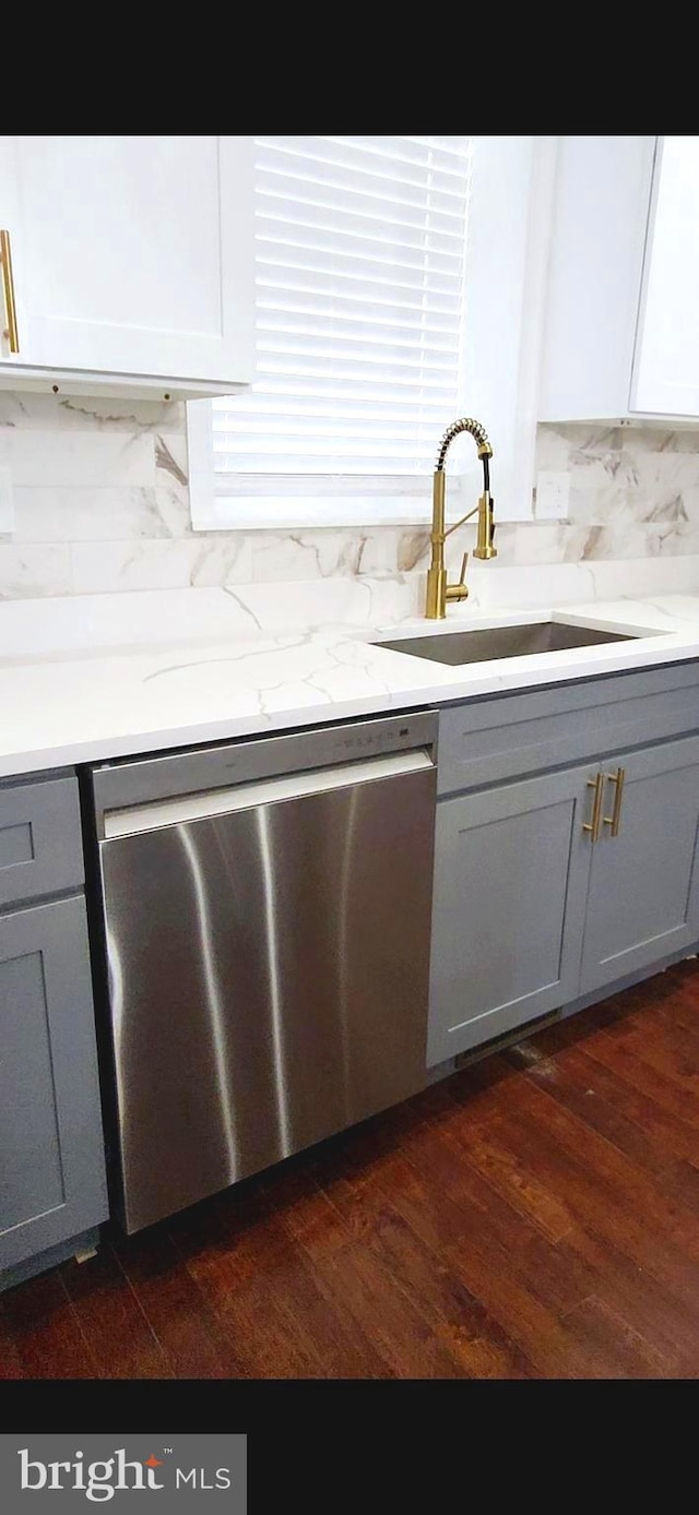 kitchen with dark wood-style flooring, gray cabinets, dishwasher, and a sink