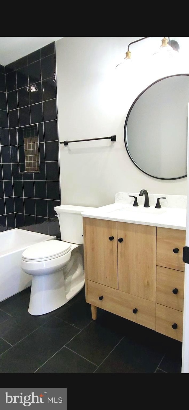 bathroom featuring toilet, tile patterned floors, a shower, and vanity