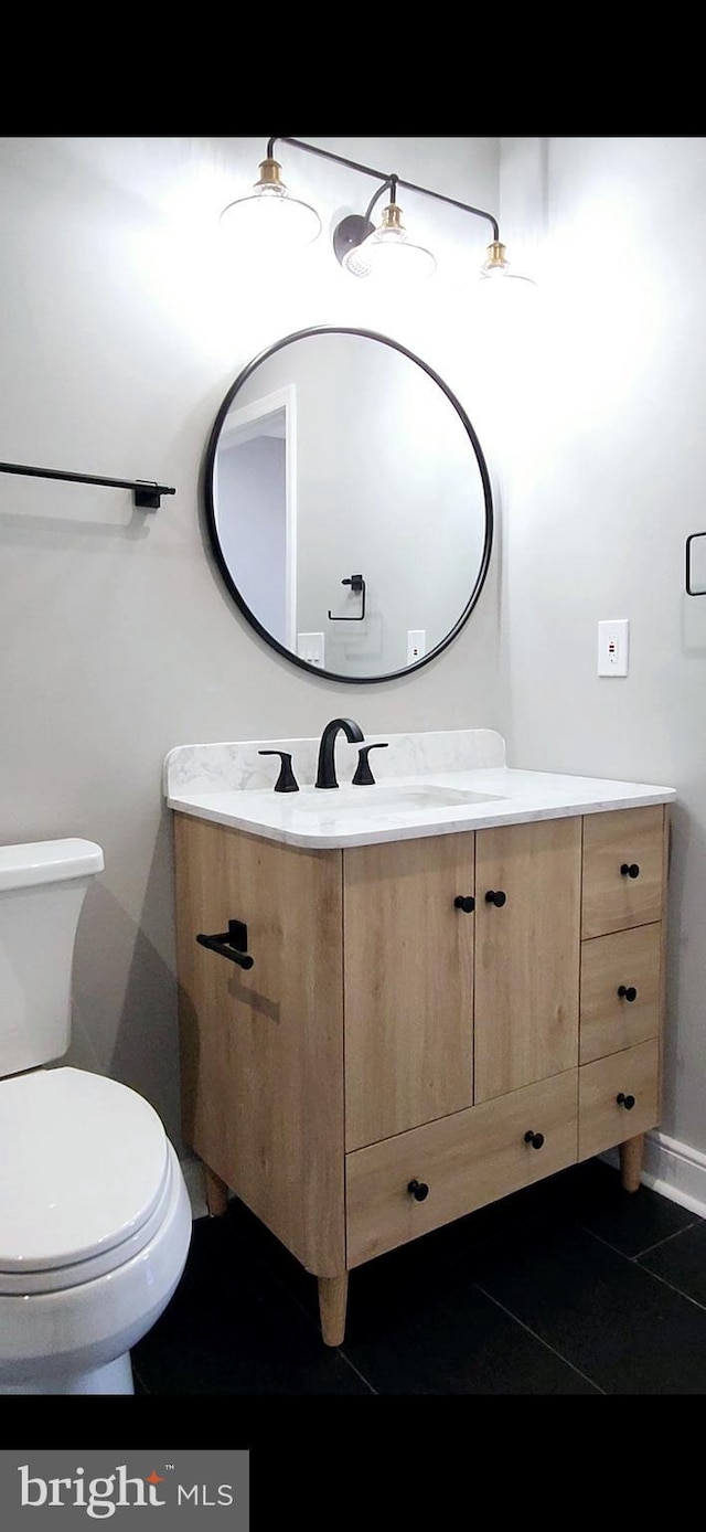 bathroom with tile patterned flooring, vanity, and toilet