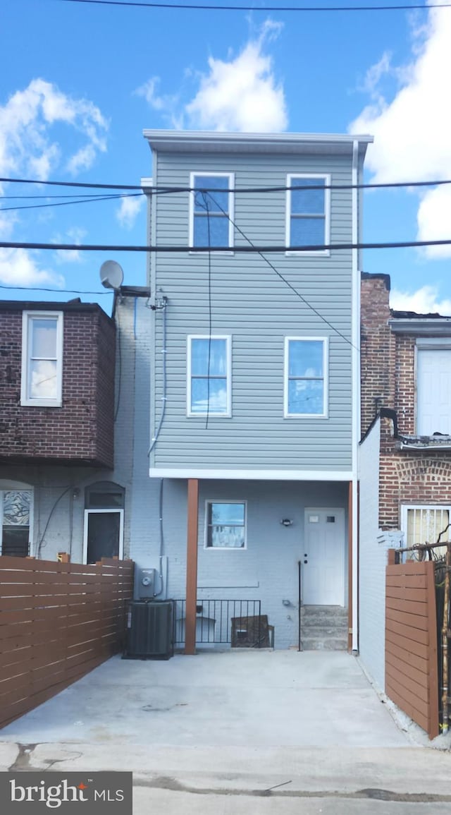 back of property with cooling unit and fence