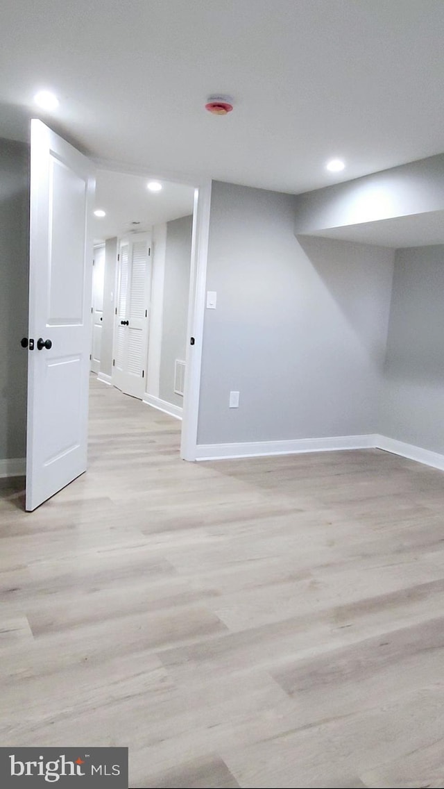 finished basement featuring recessed lighting, visible vents, light wood-style flooring, and baseboards