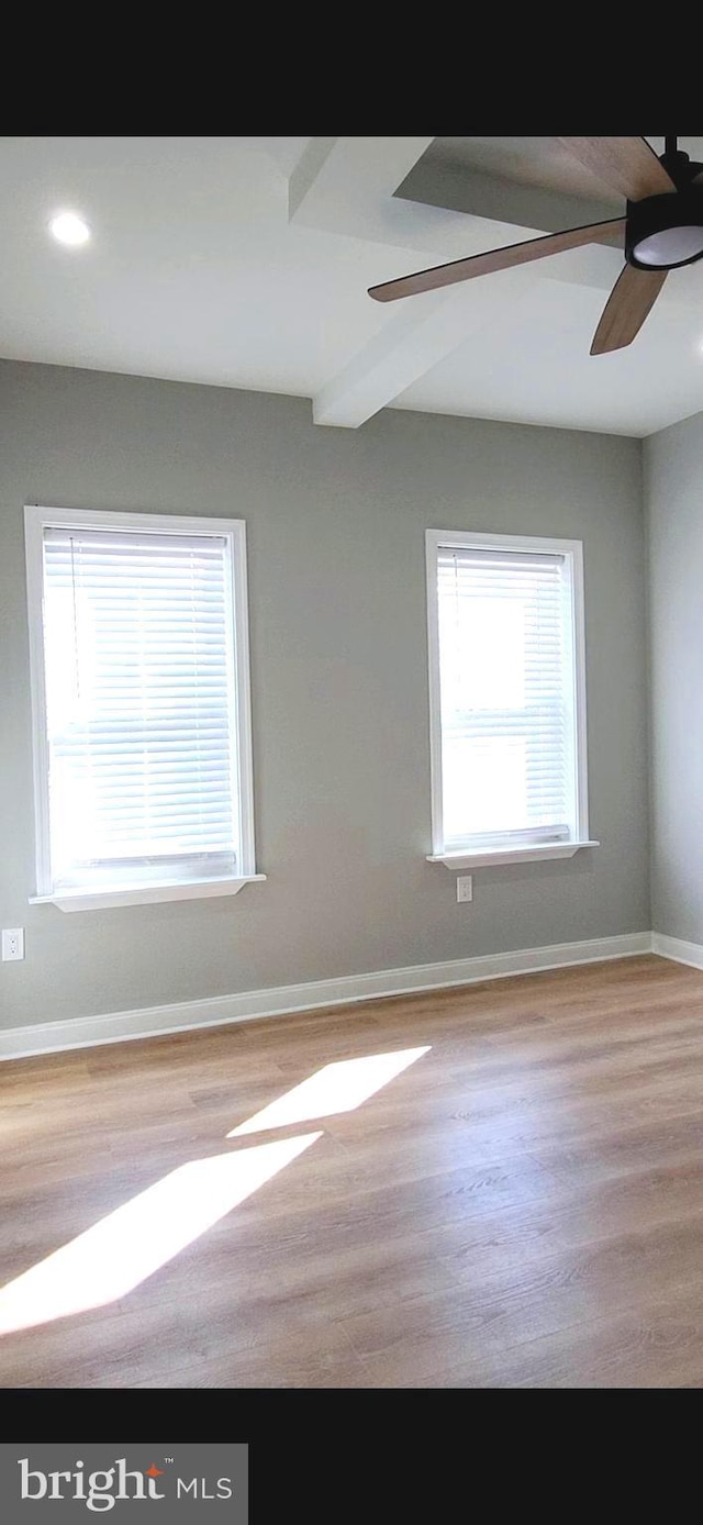 empty room featuring a ceiling fan, baseboards, and wood finished floors