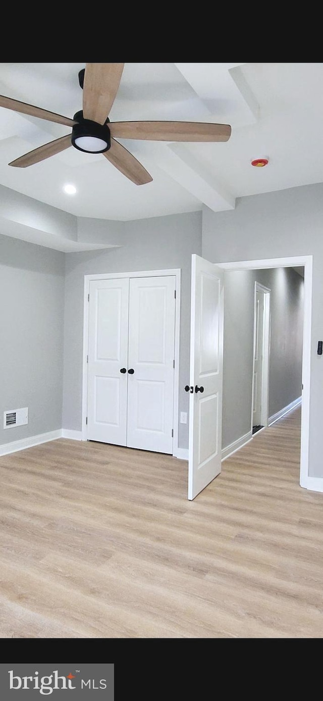 unfurnished bedroom with a ceiling fan, visible vents, baseboards, a closet, and light wood finished floors