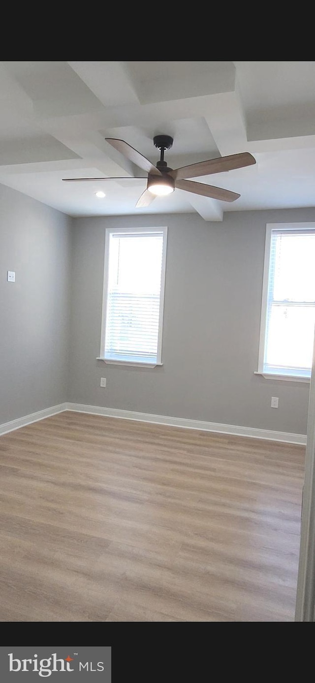 spare room featuring a ceiling fan, baseboards, and wood finished floors