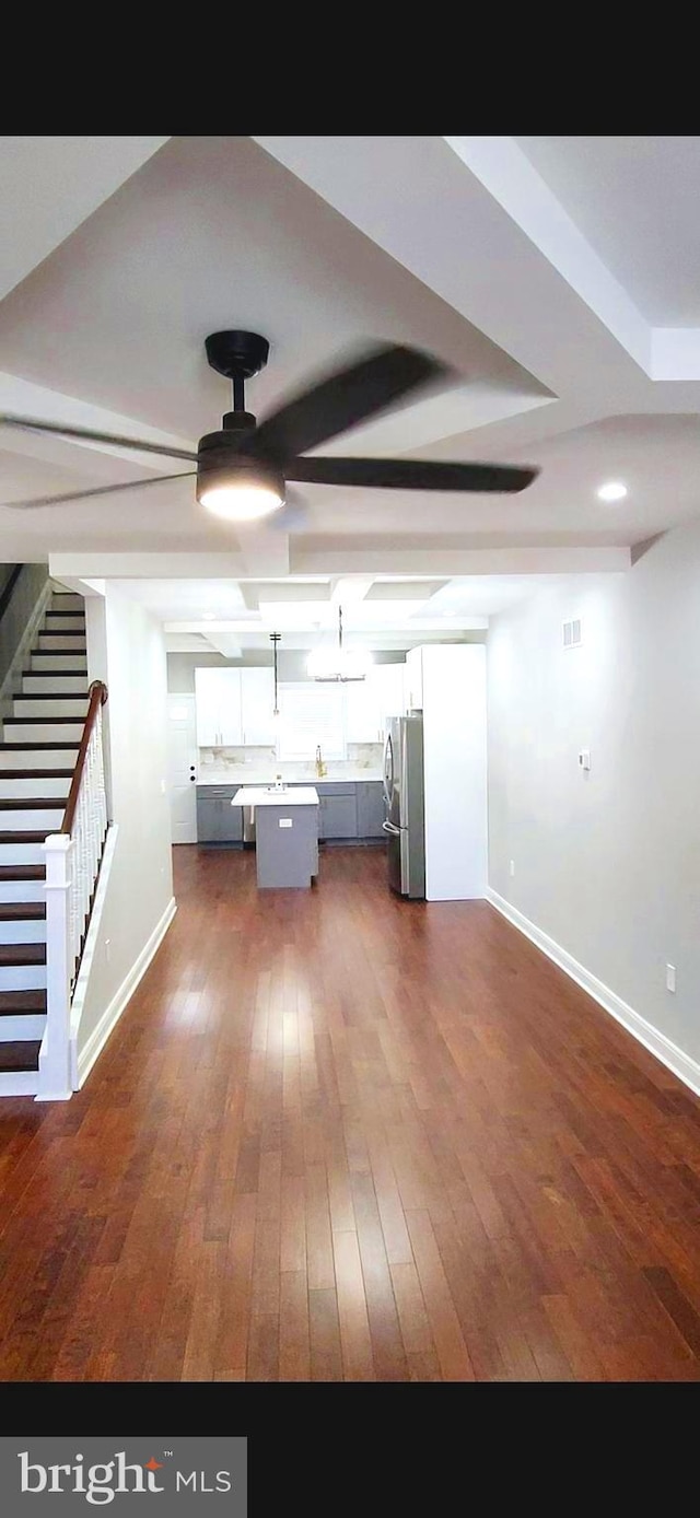 kitchen featuring dark wood-style floors, light countertops, freestanding refrigerator, white cabinets, and baseboards