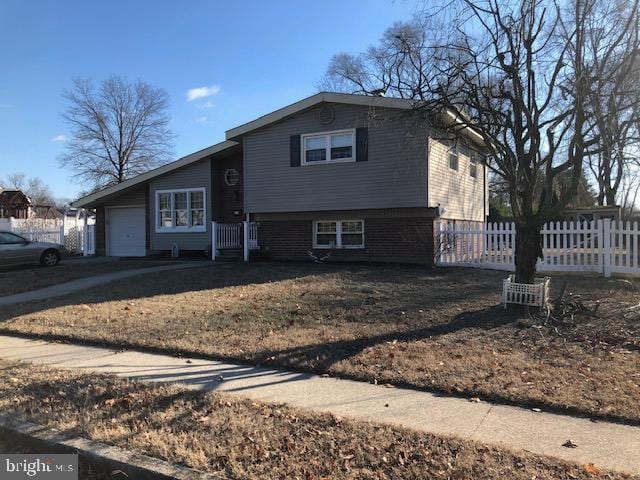 split level home featuring a garage and fence