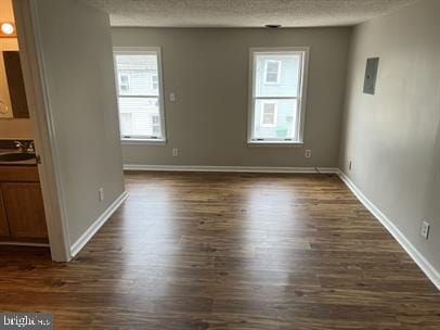 empty room featuring a textured ceiling and dark hardwood / wood-style floors