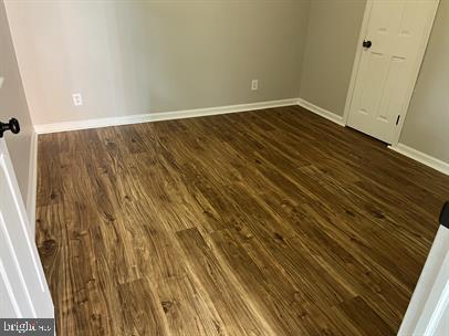 spare room with dark hardwood / wood-style flooring