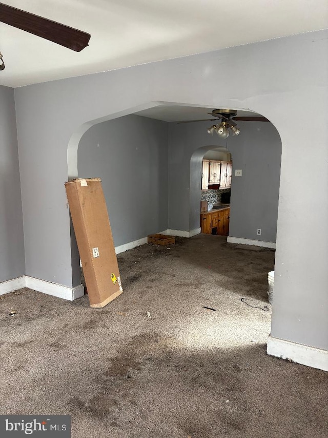 interior space with carpet flooring and ceiling fan