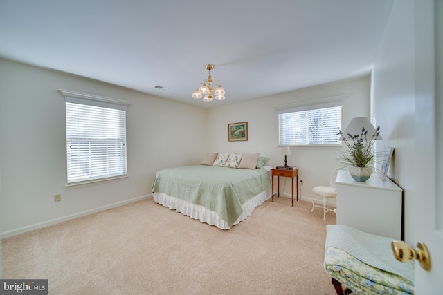 carpeted bedroom with an inviting chandelier