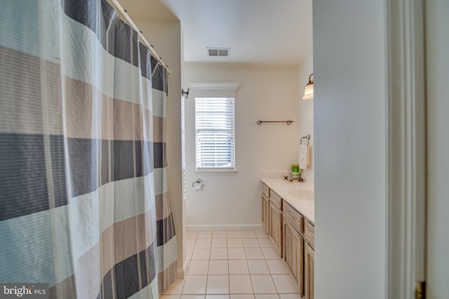 bathroom with tile patterned flooring, vanity, and walk in shower