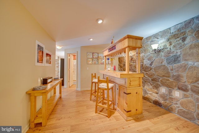 kitchen featuring kitchen peninsula, light hardwood / wood-style flooring, and a breakfast bar area