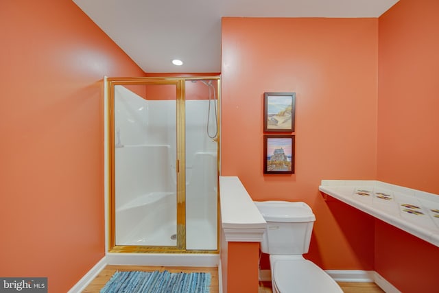 bathroom featuring hardwood / wood-style floors, toilet, and walk in shower