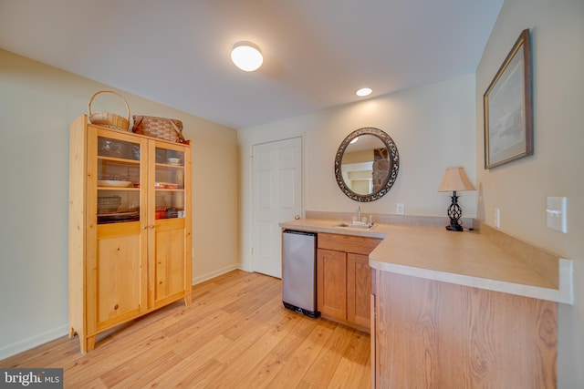 interior space featuring dishwasher, light brown cabinets, sink, and light hardwood / wood-style flooring