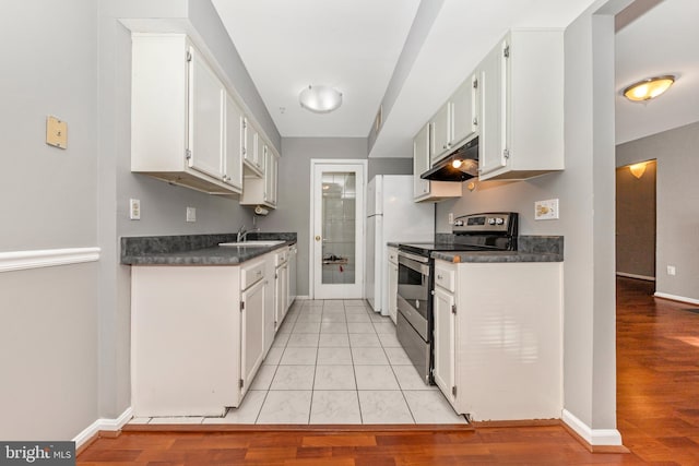 kitchen with stainless steel electric stove, white cabinets, and light tile patterned floors