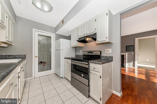 kitchen featuring white cabinetry, stainless steel electric range oven, sink, and white fridge