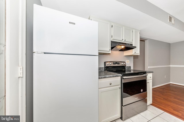 kitchen with stainless steel electric stove, white cabinets, white fridge, and light tile patterned floors