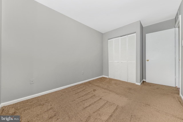 unfurnished bedroom featuring carpet and a closet