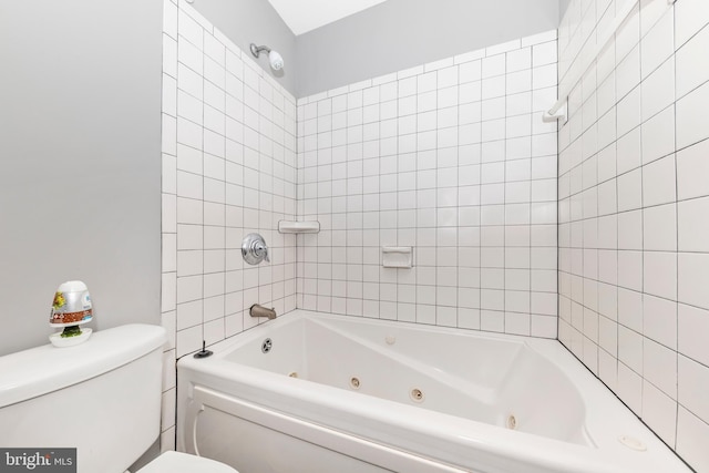 bathroom featuring toilet and tiled shower / bath