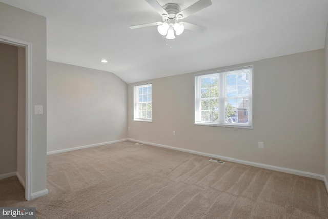 empty room with ceiling fan, light colored carpet, and lofted ceiling