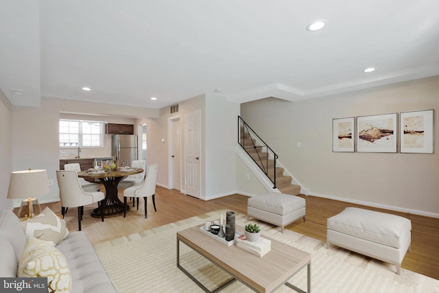 living room featuring light hardwood / wood-style floors and sink