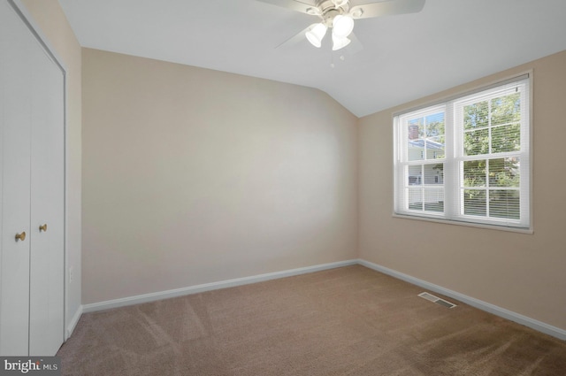 carpeted spare room with vaulted ceiling and ceiling fan