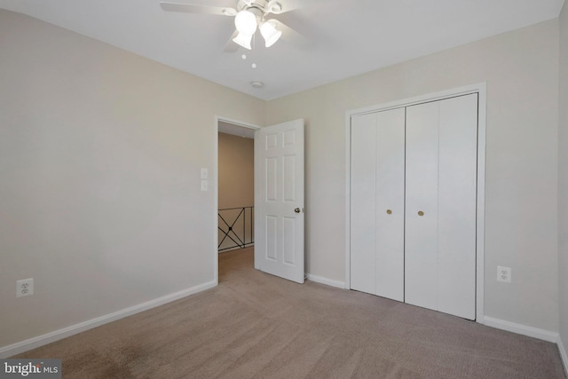 unfurnished bedroom with ceiling fan, a closet, and light colored carpet