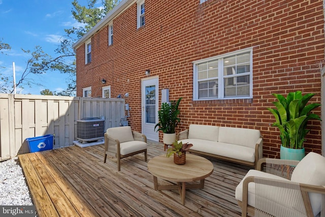 wooden deck with an outdoor living space and cooling unit