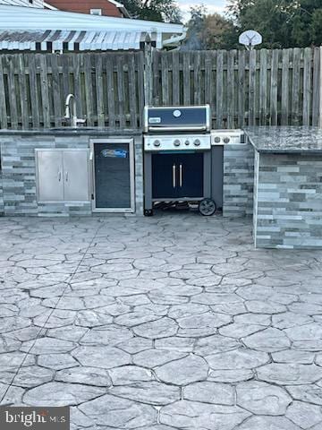 view of patio featuring a grill, area for grilling, and sink