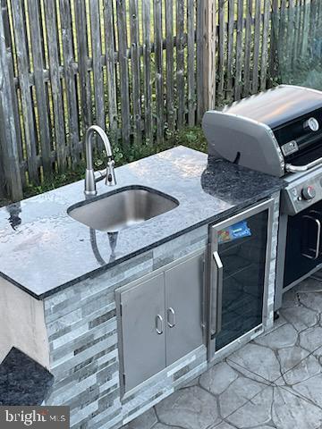 view of patio featuring a grill, area for grilling, beverage cooler, and sink