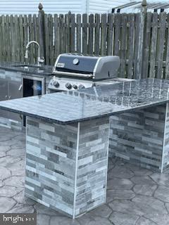 view of patio with an outdoor kitchen, area for grilling, and sink