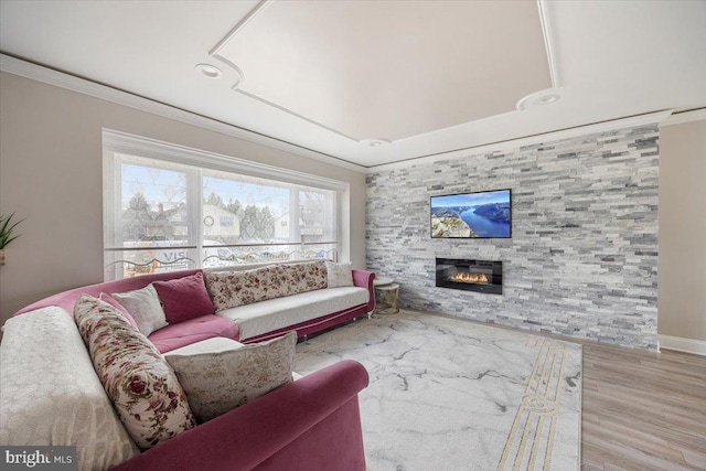 living room featuring a fireplace, light wood-type flooring, and crown molding