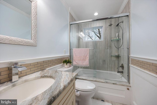 full bathroom with vanity, toilet, crown molding, and enclosed tub / shower combo