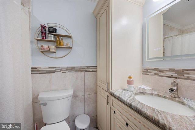 bathroom featuring vanity, toilet, tile walls, and crown molding