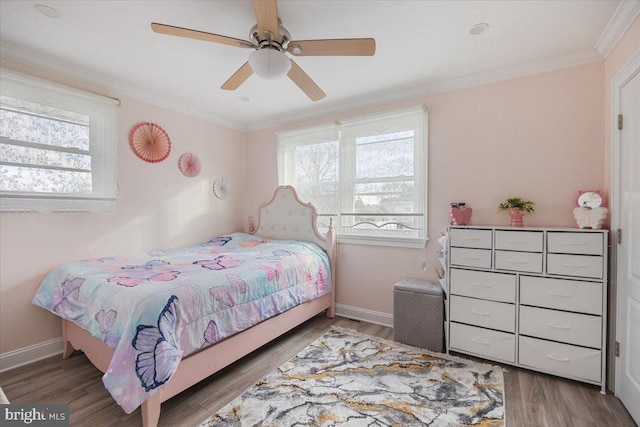 bedroom featuring multiple windows, hardwood / wood-style flooring, ceiling fan, and crown molding