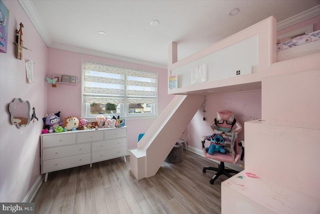 bedroom featuring light wood-type flooring and crown molding