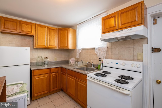 kitchen with white appliances, tasteful backsplash, under cabinet range hood, and a sink