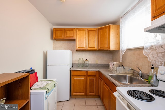 kitchen featuring under cabinet range hood, light tile patterned floors, backsplash, and white appliances