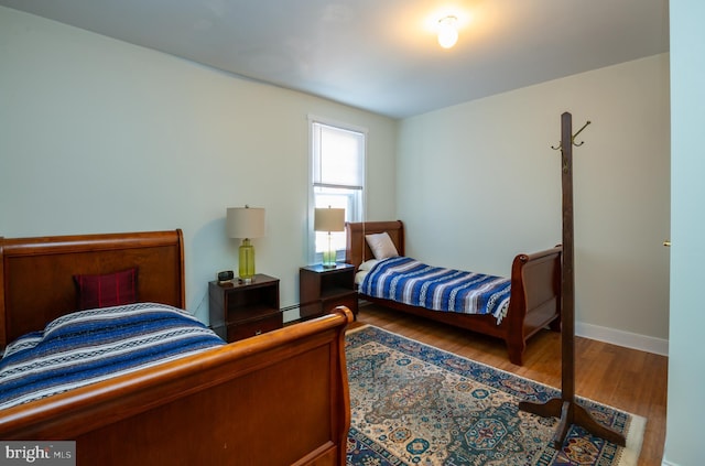 bedroom featuring baseboards and wood finished floors