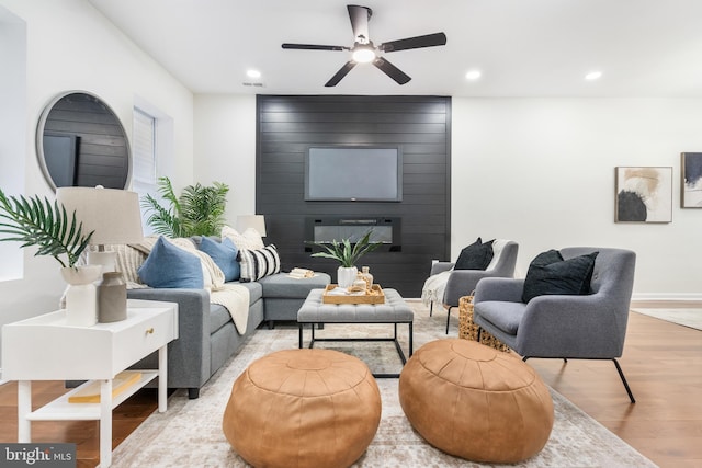 living room featuring hardwood / wood-style floors and ceiling fan