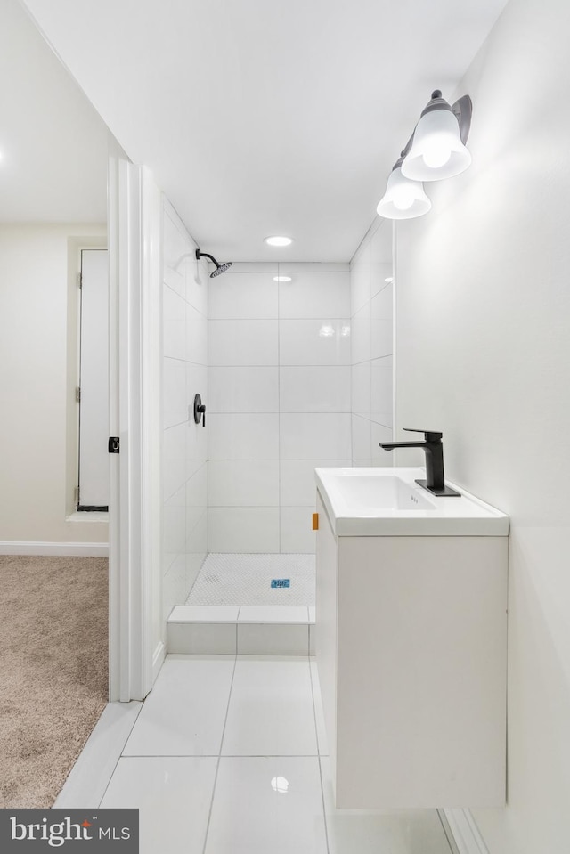 bathroom with tiled shower, vanity, and tile patterned floors