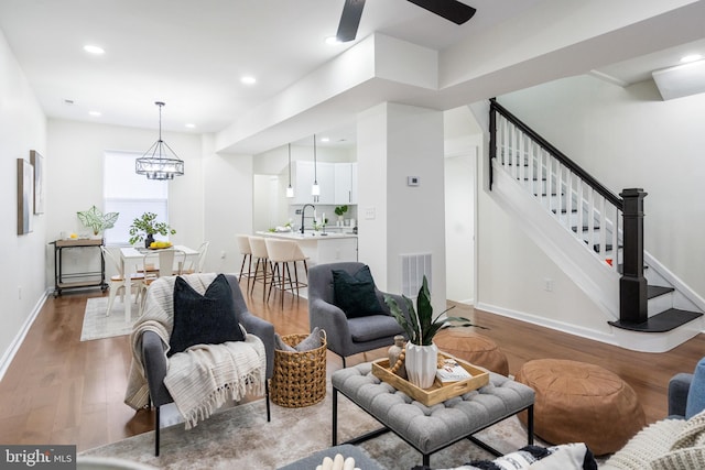 living room featuring dark hardwood / wood-style floors, an inviting chandelier, and sink