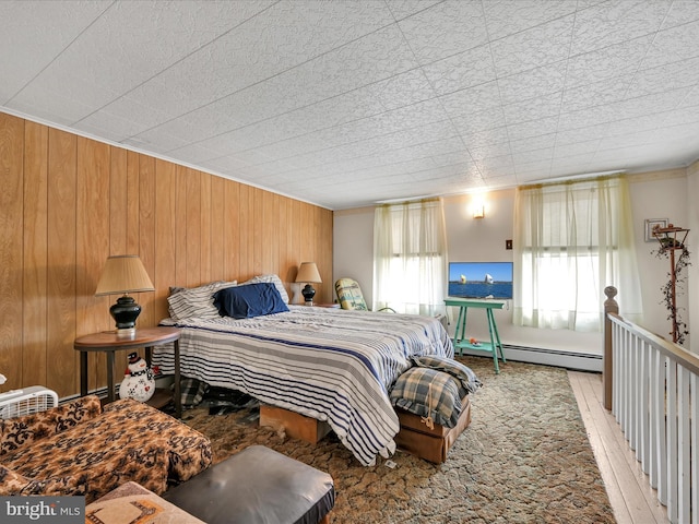 bedroom featuring wood walls and baseboard heating