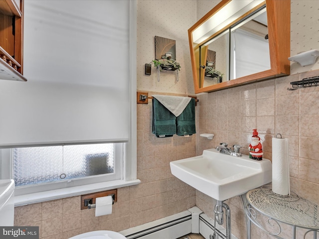 bathroom with tile walls, toilet, baseboard heating, and sink