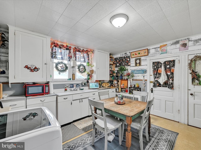 kitchen with white cabinetry, sink, and washer / dryer