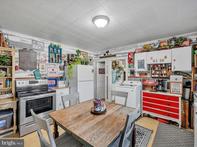 kitchen with white cabinetry, white fridge, washer / dryer, electric stove, and light tile patterned flooring